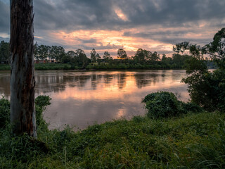 Fototapeta na wymiar Beautiful Riverside Sunset with Dramatic Sky and Cloud Reflections