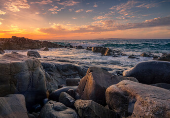 Beautiful Coastal Sunset with Waves Crashing on Rocks