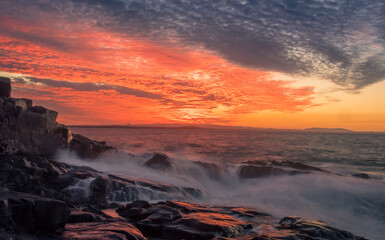 Coastal Sunset with Waves Crashing on Rocks