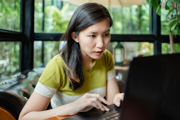 Asian women are using their laptops to work in coffee.