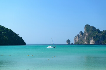 A sailboat moored off the shore in front of Loh Dalum Beach, Loh Dalum Bay, Koh Phi Phi Don, Krabi, Thailand.