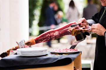an Iberian ham cutter, cutting slices of the ham leg