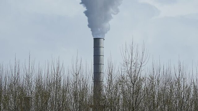 smoking chimney of a factory against sky in Germany