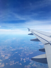 Flugzeugpassagier blickt beim Fliegen in Urlaub auf Tragfläche, auch Tragflügel, Flügel. Das...