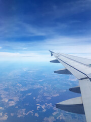 Flugzeugpassagier blickt beim Fliegen in Urlaub auf Tragfläche, auch Tragflügel, Flügel. Das unter einem Bootsrumpf montierte Tragflügelboot, ist ein Bauteil für dynamischem Auftrieb.