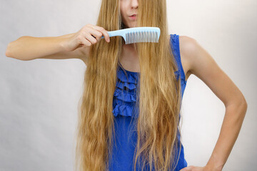 Woman combing long healthy blonde hair