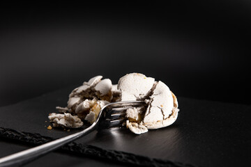 Macarons zerquetscht mit einer Gabel, Krümel, schwarzer Hintergrund.
