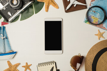 Top view photo of sunglasses sunhat camera map magnifier plane model on passport cover yacht toy palm leaf starfishes pen notebook and smartphone in the middle on isolated wooden white background