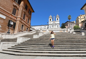cute girl comes down the steps of PIAZZA DI SPAGNA in Rome in Italy and there are no other people...