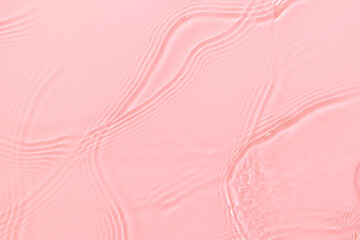 de-focused. Closeup of pink transparent clear calm water surface texture with splashes and bubbles. Trendy abstract summer nature background. Coral colored waves in sunlight. Copy space