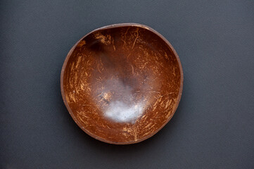Wooden round plate of coconut on black background