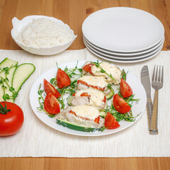 Baked fillet of codfish served with zucchini and tomatoes. Healthy food