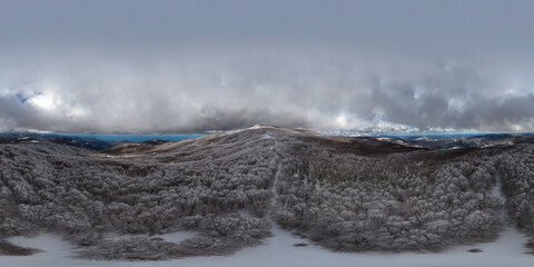 360 degrees photo of the beech forest of the Nebrodi mountains in Sicily during a light snowfall in early spring. View of Etna. Monte Soro and the Aeolian Islands with the Tyrrhenian Sea. 
