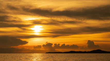 sunset time over sea or ocean with island.