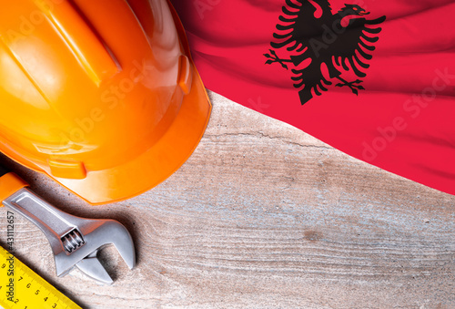 Albania flag with different construction tools on wood background, with copy space for text. Happy Labor day concept.