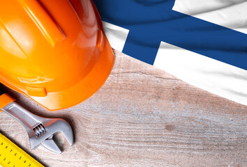 Finland flag with different construction tools on wood background, with copy space for text. Happy Labor day concept.