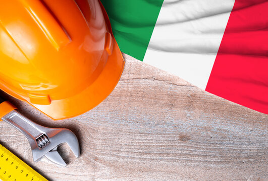 Italy flag with different construction tools on wood background, with copy space for text. Happy Labor day concept. - Powered by Adobe