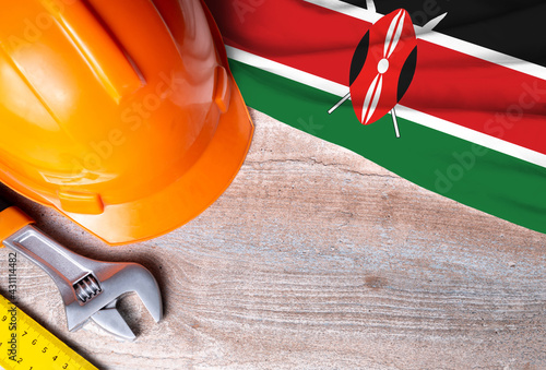 Kenya flag with different construction tools on wood background, with copy space for text. Happy Labor day concept.