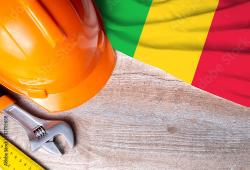 Mali flag with different construction tools on wood background, with copy space for text. Happy Labor day concept.