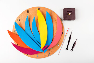 DIY and kid's creativity. Step by step instruction: how to wall clock. Step2 childs hands separate colored parts for wall clock. Children Craft workshop