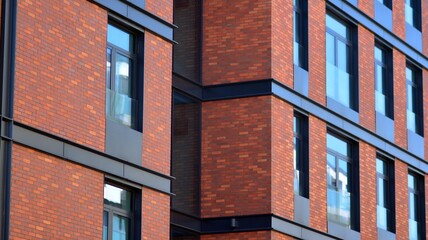 Architectural exterior detail of residential apartment building with brick facade. Modern brick and glass facade of the apartment building.