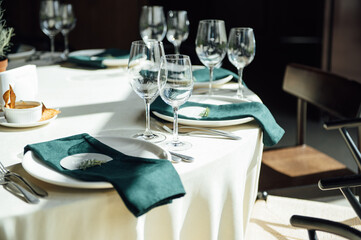 Luxurious restaurant. Luxurious interior, white tables, serving dishes and glasses for guests