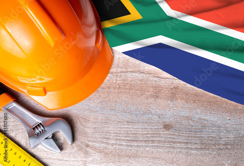South Africa flag with different construction tools on wood background, with copy space for text. Happy Labor day concept.
