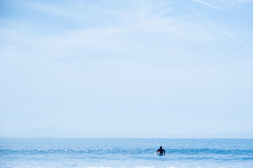 水平線が見える海原で波を待つサーファー　