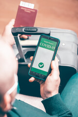 Person in airport using mobile app in phone to show covid-19 test results for travel
