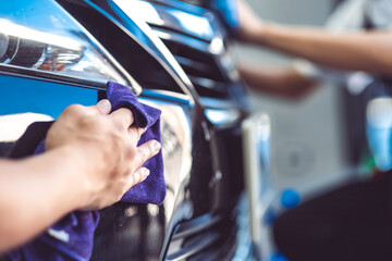 Paint protection film installation on door panel of luxury sports car. PPF is polyurethane film...