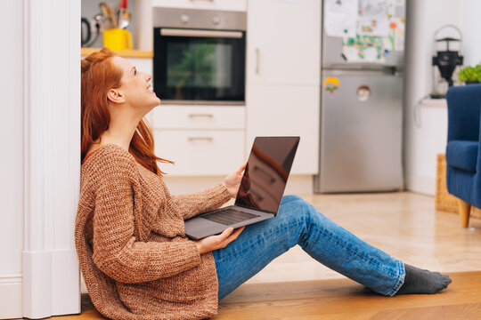 Happy young woman relaxing with a laptop computer