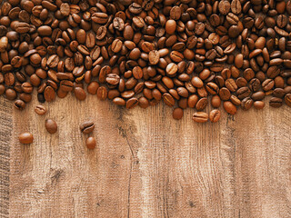 Roasted coffee beans on a wooden surface. Place for an inscription.