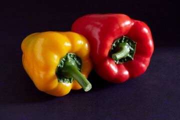 Sweet peppers of red and yellow color on a dark background