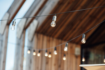 Evening illumination in the courtyard with the background of a modern wooden house