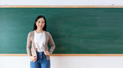 Portrait of a young Asian teacher smiling happily in front of the classroom. Close up women student...