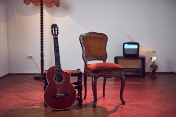 Acoustic guitar with retro vintage furniture at home.