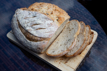 Seeded Bread, bread making, home made bread, sourdough, natural yeast bread, rustic bread, home baking, sun over a loaf of bread. sliced bread, slices of bread on a wooden chopper,