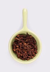 Small trial portion of dry cloves on platter isolated on white background. Design element with clipping path