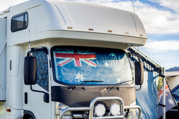 Motorhome campervan with flag of Australia on the windscreen at the campground. Australian camping...