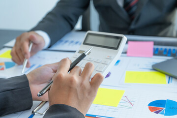hand use calculator, businesswomen and businessmen team meeting to plan strategies to increase business income. Have a brainstorming finance graph analysis and discussing for the new target success