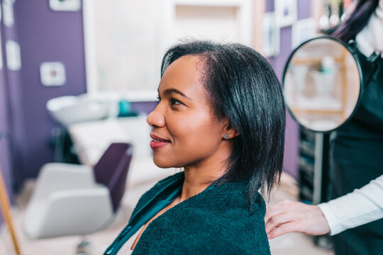 Middle aged African American woman enjoying in modern hair salon. Beauty, fashion concept.