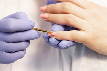 Manicure. Strengthening of natural nails with artificial material-gel. Nail care in a beauty salon. Close-up