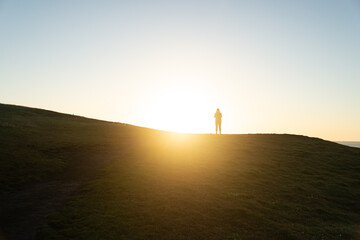 Silhouette of Person against Sunrise on a Hill. Lifestyle and Nature Concept