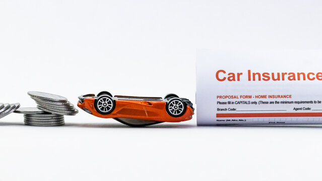 Accidental Vehicle insurance concept shown by a car crash, coins, and documents.