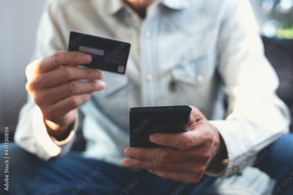 Poster man using mobile phone and credit card for online shopping and internet payment via digital mobile b