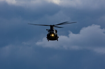 Helicopter flying under blue cloudy sky