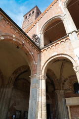 Perspective of the bell tower of the famous Sant'Ambrogio (meaning Saint Ambrogio) romanesque cathedral in Milan, Italy. Blue sky on the background.