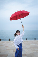 雨の中で傘を差す女性