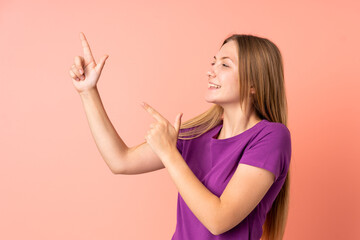 Teenager Ukrainian girl isolated on pink background pointing with the index finger a great idea