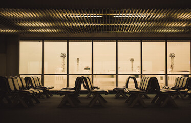 Empty airport terminal waiting area because of the coronavirus COVID 19. Empty seats in the departure lounge or terminal at the airport.